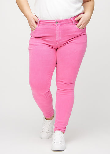 Lyserøde skinny jeans, modelnavn Flamingos, som sidder tæt til benet på en plus-size model, set forfra.