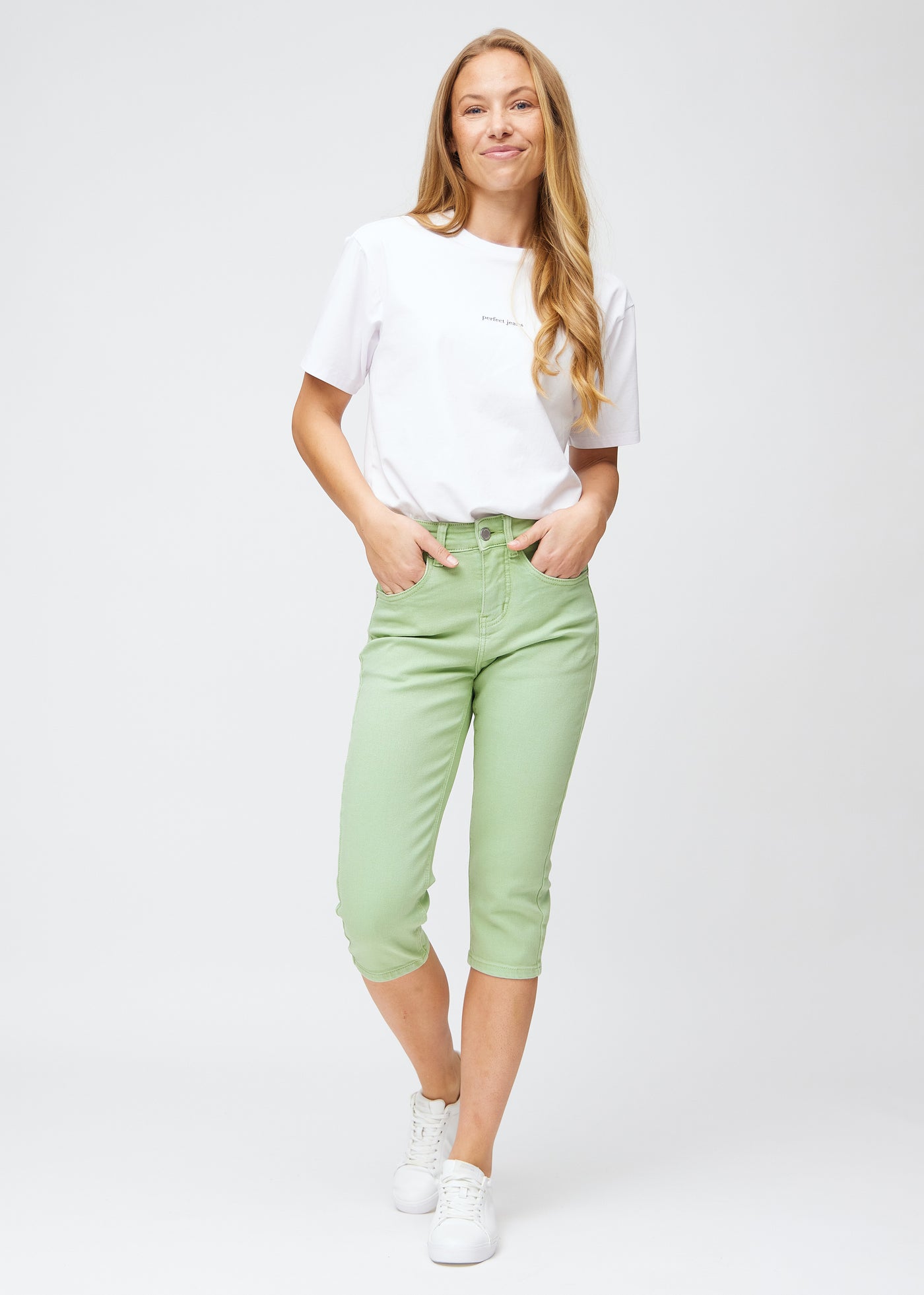 Fuldt billede af model iført lysegrønne slim capris.