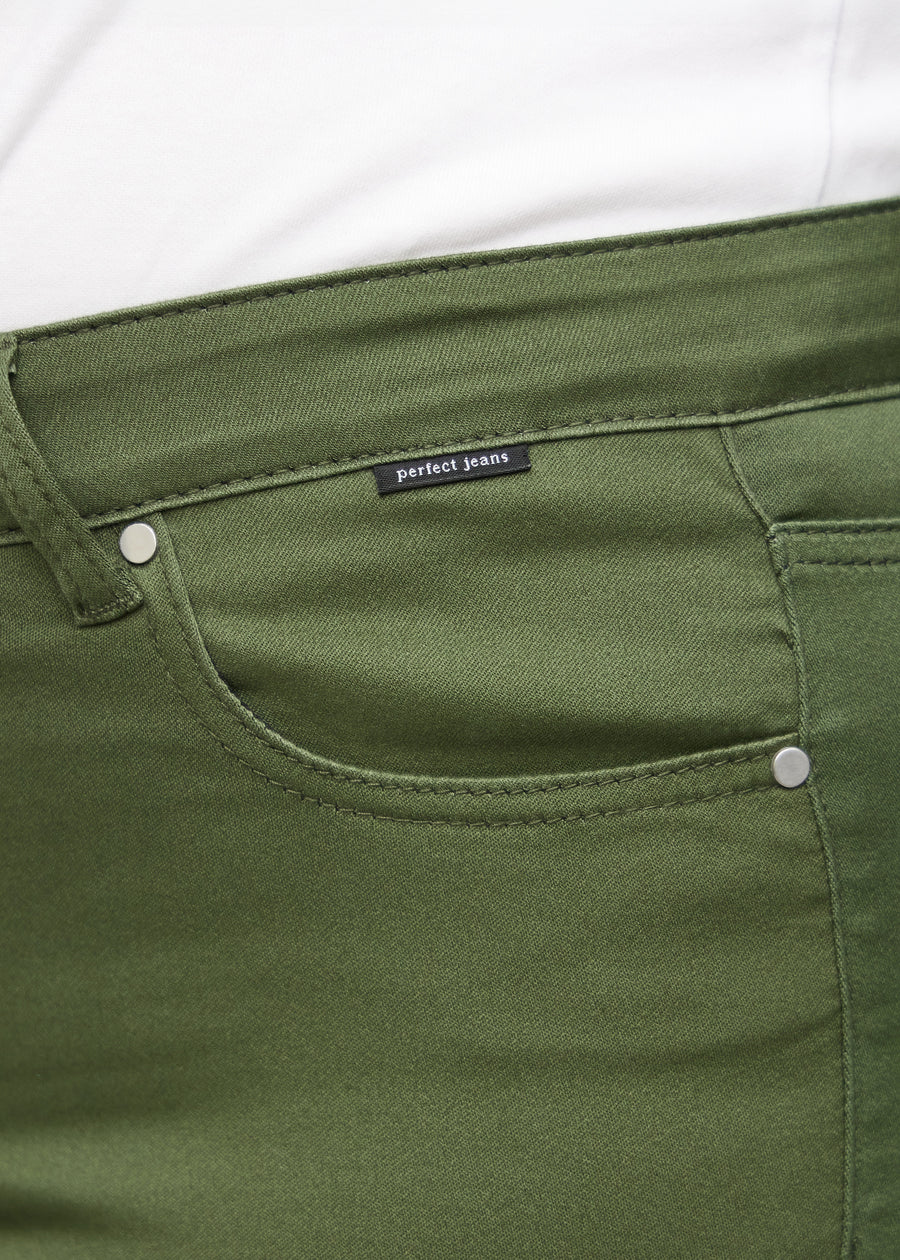 Forlommen på et par mørkegrønne slim jeans, hvor man kan se logoet på en plus-size model.