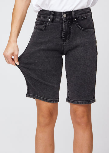 Kvinde der strække i et par knælange mørkegrå denim shorts