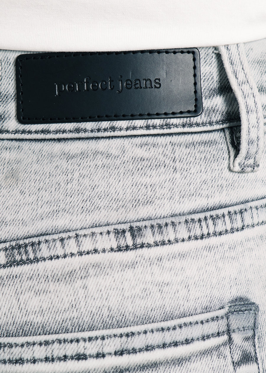 Nærbillede af lysegrå denim med Perfect Jeans læderpatch bagpå i taljen, på en plus-size model.