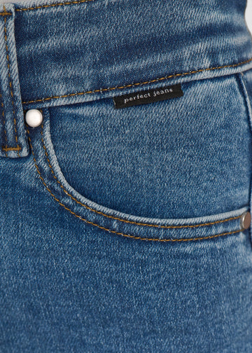 Nærbillede af mørkeblå denim med Perfect Jeans logoetiket ved forlommekanten.