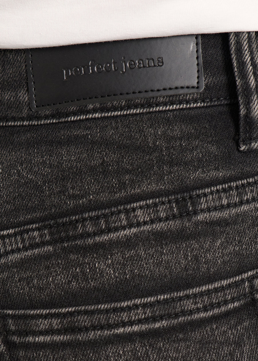 Nærbillede af mørkegrå denim med Perfect Jeans læderpatch bagpå i taljen.