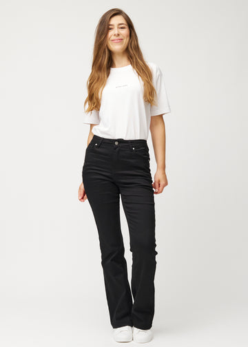 Black mid-rise bootcut jeans in Ravens. Full-length view of a model wearing the jeans.