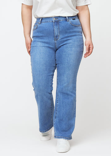 Blå mid-rise bootcut jeans i denimfarven Rivers, modelnavn Ravens, som sidder tæt fra hofte til lår og har et let svaj forneden, på en plus-size model, set forfra.