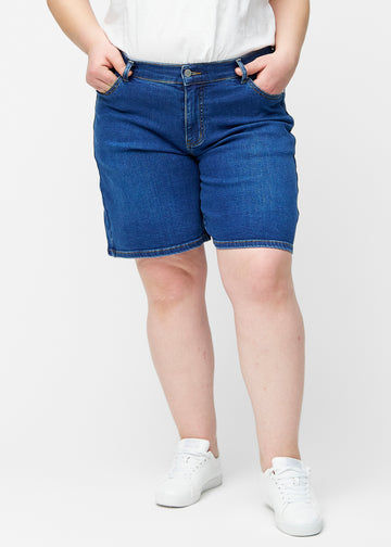Løse, mørkeblå denim shorts i farven Oceans set forfra på plus-size model, der sidder til ved hoften og falder løst ned.