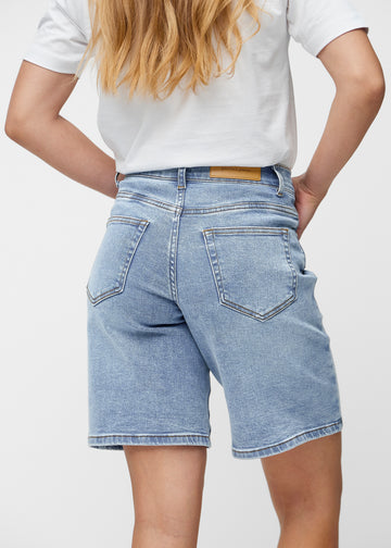 Loose, light blue denim shorts in the colour Waves seen from the back up close to show fit and details.