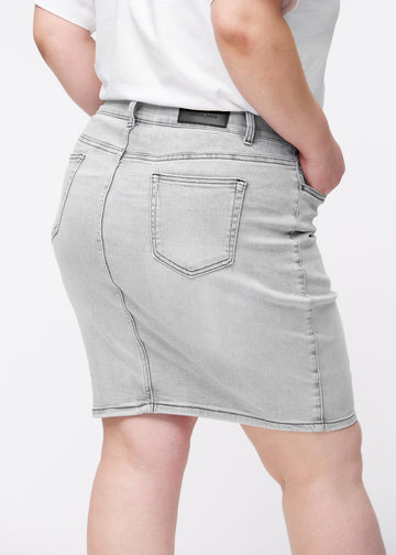 Lysegrå, tætsiddende og knælang denimnederdel set bagfra tæt på på plus-size model for at vise detaljer.