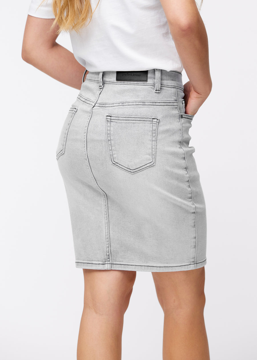 Lysegrå, tætsiddende og knælang denimnederdel set bagfra tæt på for at vise detaljer.