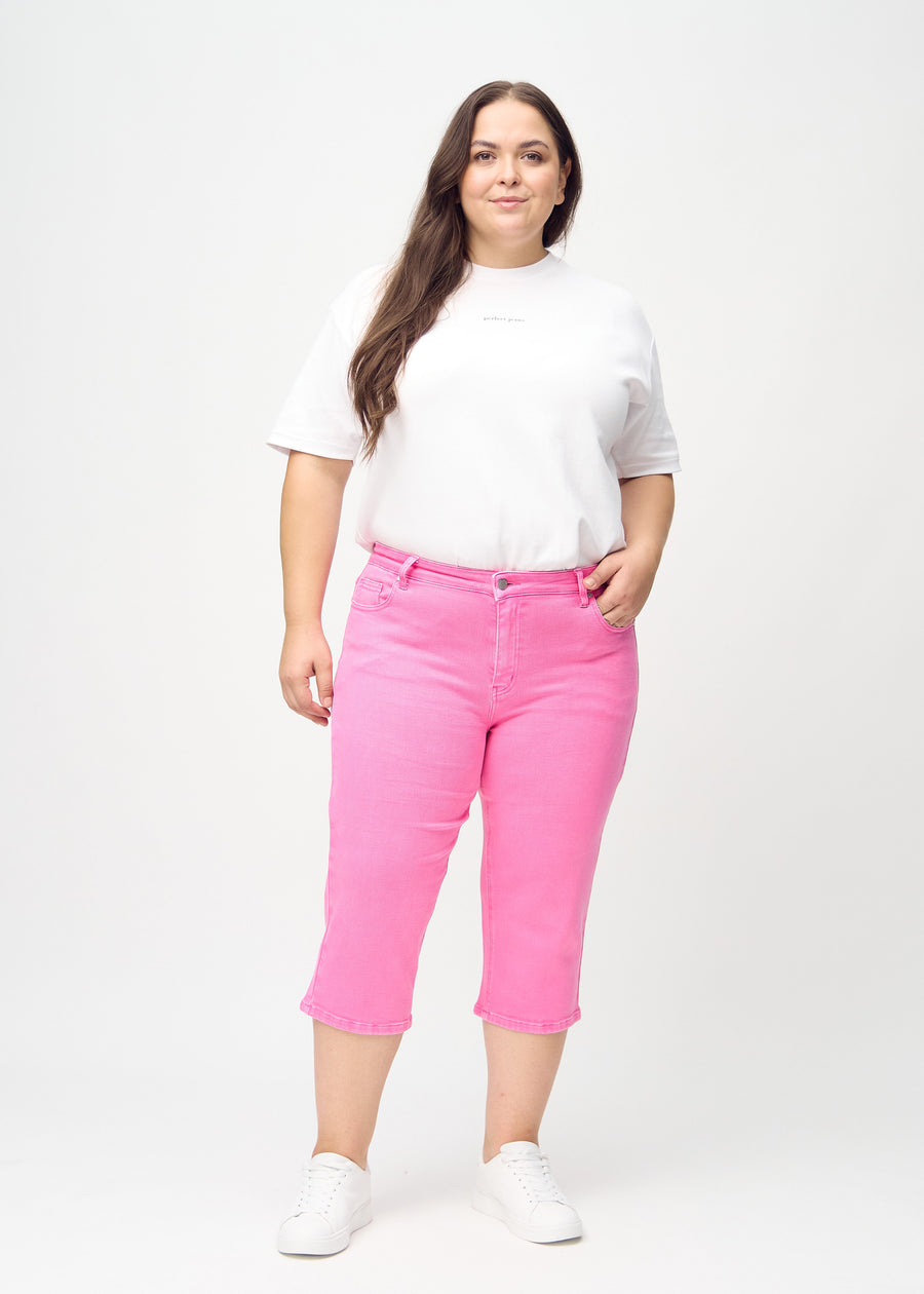 Full image of a plus-size model in light pink regular capris.