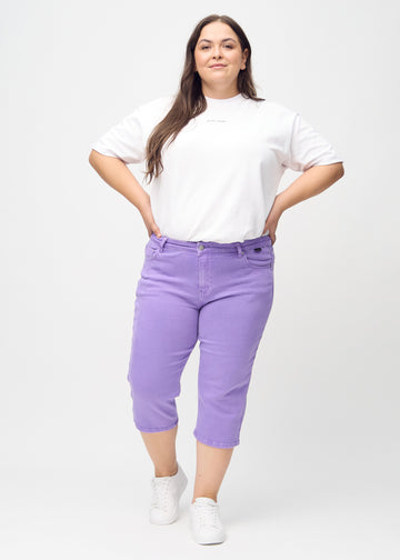 Full-length image of a plus-size model in purple regular capris.