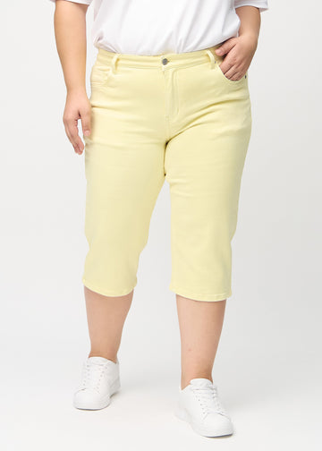 Light yellow regular capris, model name Lemonades, with a straight leg on a plus-size model, seen from the front.