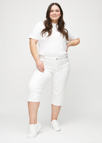 Full image of a plus-size model in white regular capris.