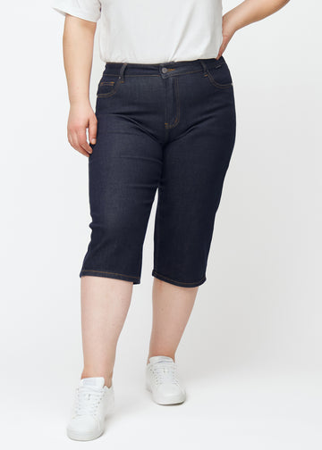 Deep dark blue denim capris for women in the colour Midnights with a regular fit seen from the front on a plus-size model.