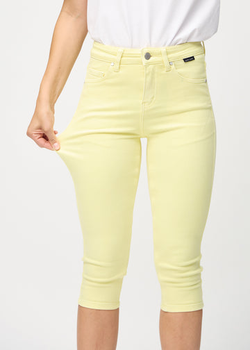 Woman stretching in a pair of light yellow capris