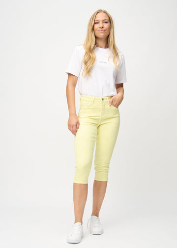 Woman wearing light yellow capri pants from Perfect Jeans.