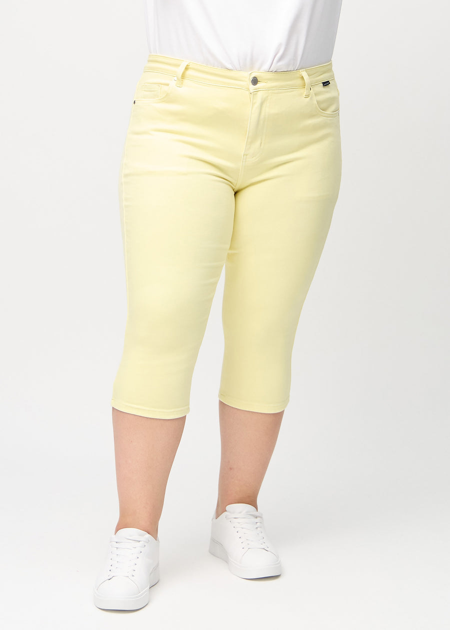 Light yellow skinny capris, model name Lemonades, fitted close to the leg on a plus-size model, front view.