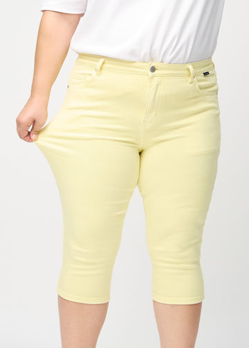 Plus-size model stretching the capris at the thigh to show stretch.