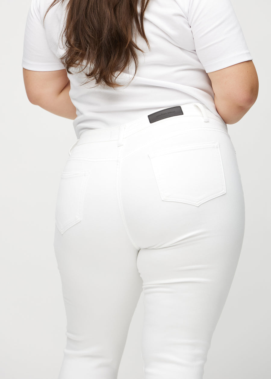 White skinny capris seen from the back in close-up on a plus-size model to show details.