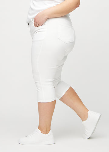 White skinny capris seen from the side on a plus-size model.