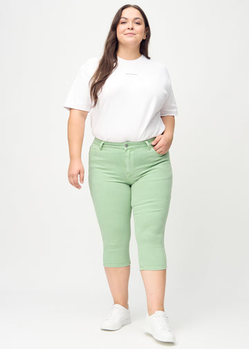Skinny capris for women in pastel green fabric, color Mints. Full-length view of a plus-size model wearing the capris.