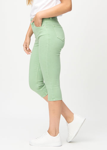 Skinny capris for women in pastel green fabric, color Mints. Side view on a model, showing the fitted cut.