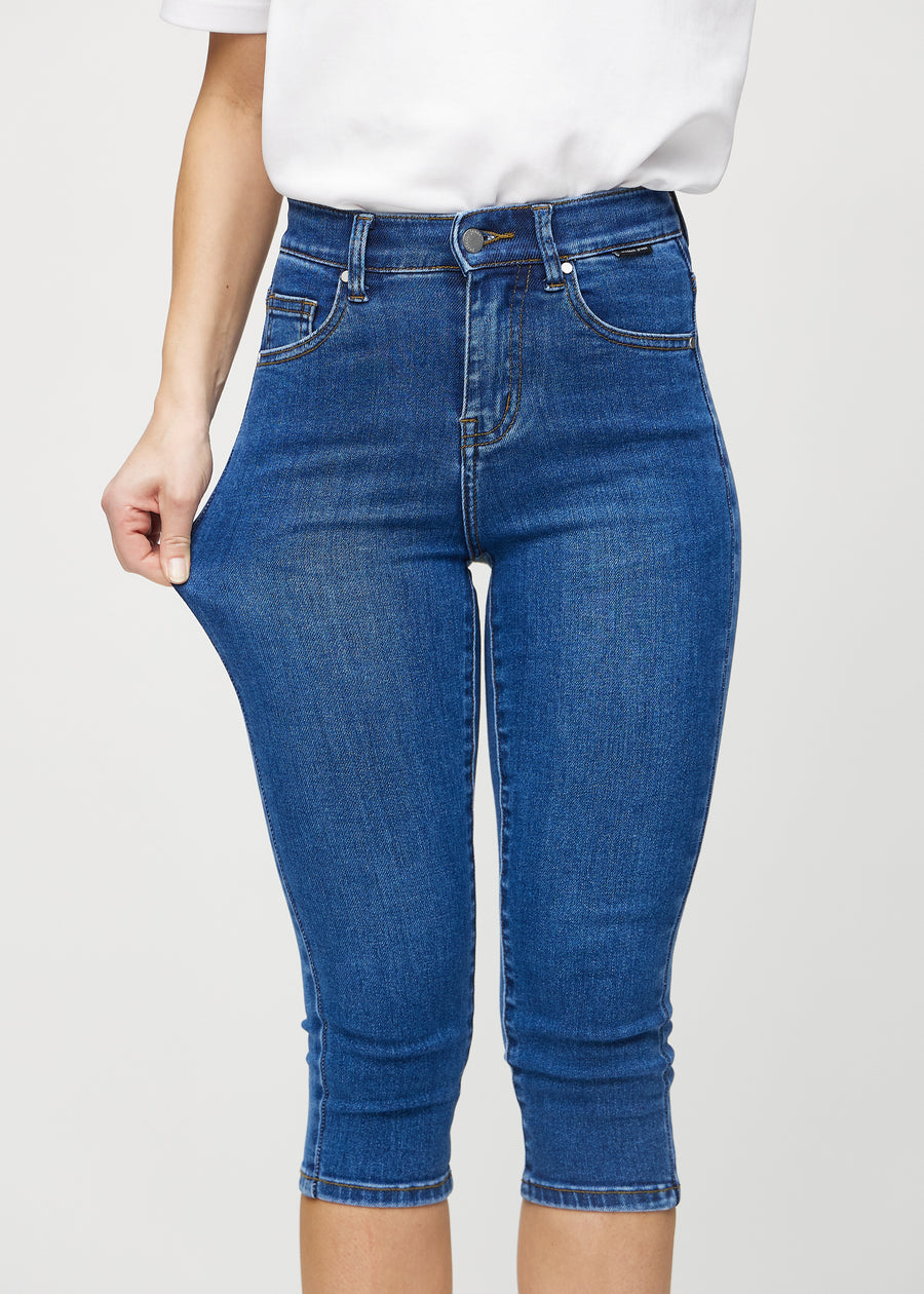The model stretches the capris at the thigh to show the stretch.