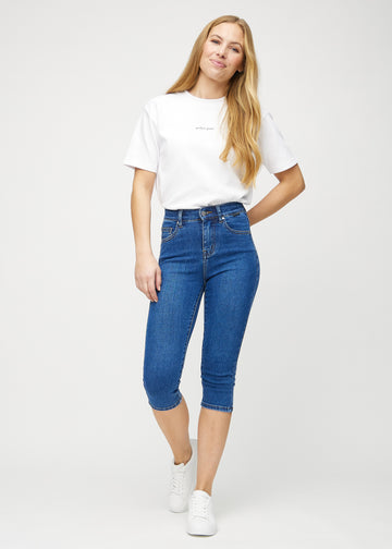 Full image of model in dark denim skinny capris.