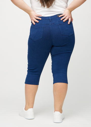 Dark blue skinny capris seen from the back on a plus-size model, so the full product can be seen.