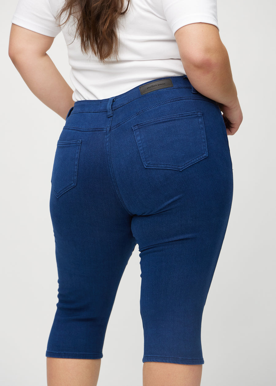 Dark blue skinny capris seen from the back close up on a plus-size model to show details.