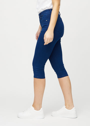 Dark blue skinny capris seen from the side on a model.