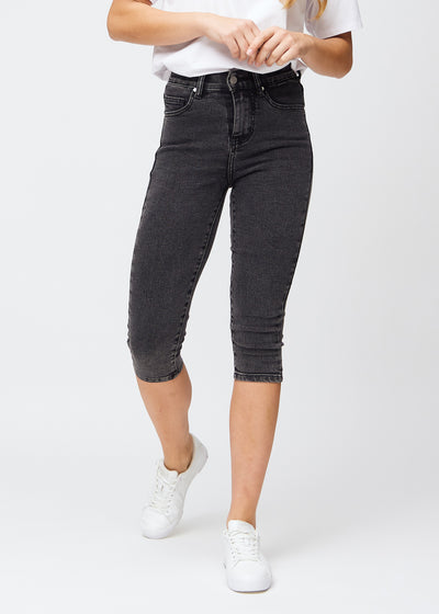 Dark grey denim skinny capris, model name Shadows, which fit close to the leg and end just below the knee, seen from the front.