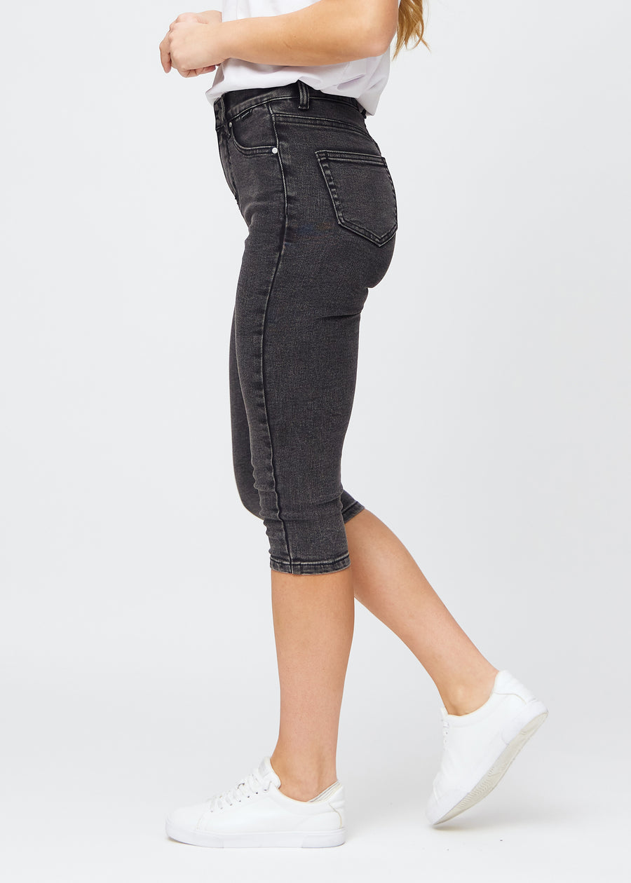 Dark grey denim skinny capris seen from the side on a model.