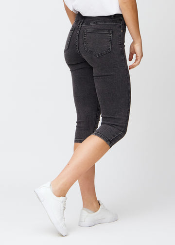 Dark grey denim skinny capris seen from the back, so the entire product can be seen.