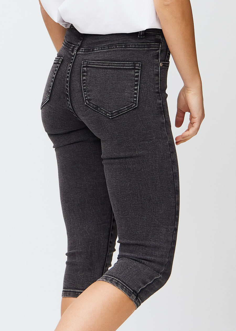 Dark grey denim skinny capris seen from the back up close to show details.