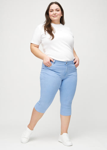 Skinny capris for women in light blue fabric, color Skies. Full-length view of a plus-size model wearing the capris.