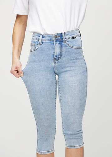 The model stretches the capris at the thigh to show the stretch.