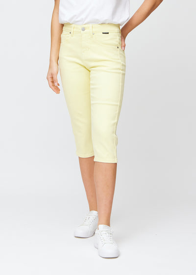 Light yellow slim capris, colour Lemonades, with a close-fitting fit that shapes the legs and ends just below the knee, seen from the front.