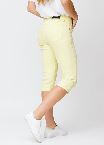 Light yellow slim capris seen from the back, the full product is shown on the model with focus on fit and length.
