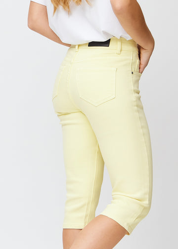 Light yellow slim capris seen from the back, the full product is shown on the model with focus on fit and length.