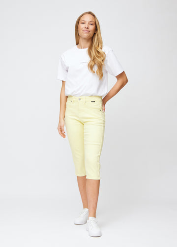 Full image of model wearing light yellow slim capris.