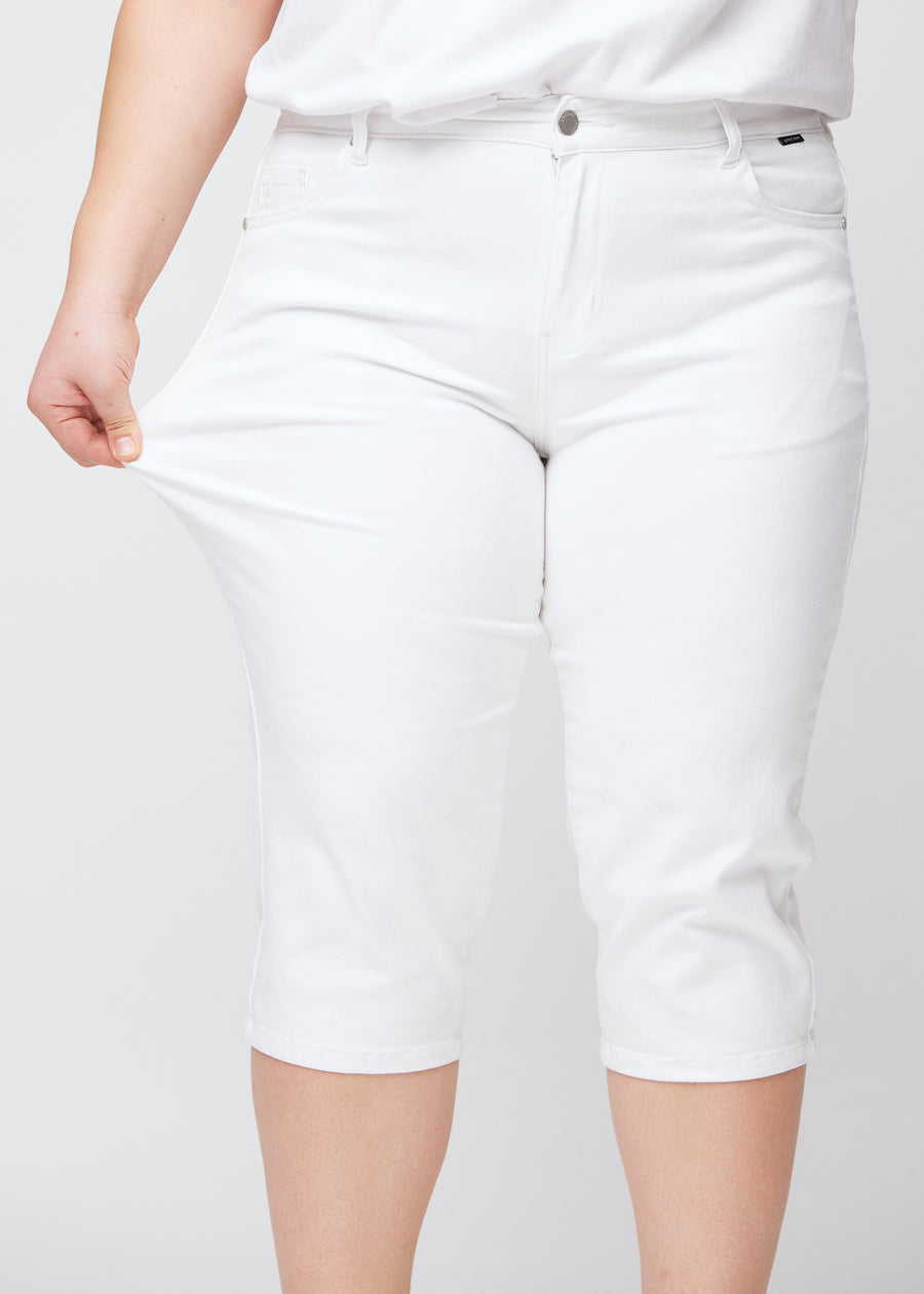 Plus-size model shows the stretch by pulling the capris at the thigh, focus on comfort and flexibility.