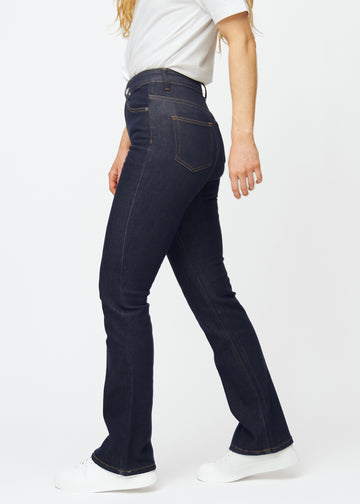 Deep dark blue denim jeans for women in the color Midnights with a bootcut fit seen from the side on a model.