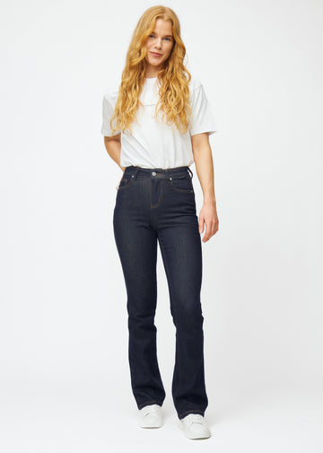 Full image of a model in deep dark blue denim jeans for women in the color Midnights with a bootcut fit.