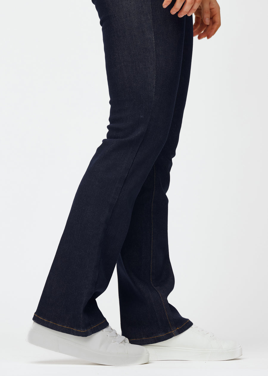 Deep dark blue denim jeans for women in the color Midnights with a bootcut fit seen in close-up at the ankles to show the slight flare.