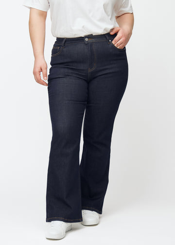 Deep dark blue denim jeans for women in the color Midnights with a bootcut fit seen from the front on a plus-size model.