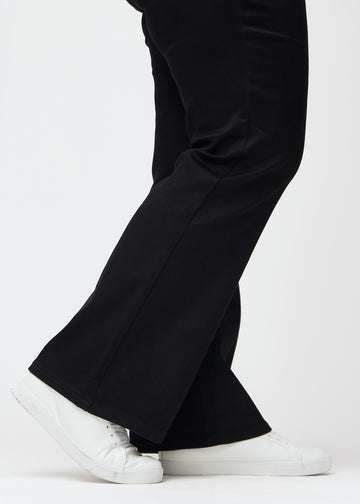 The ankles of a plus-size model, so the slight flare in the pant leg can be seen, in a Bootcut fit.