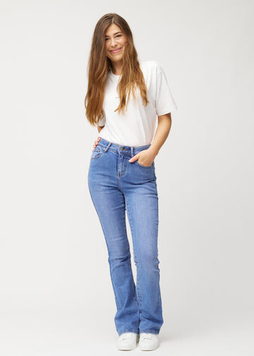 Fuldt billede af model i blå mid-rise bootcut jeans i denimfarven Rivers.