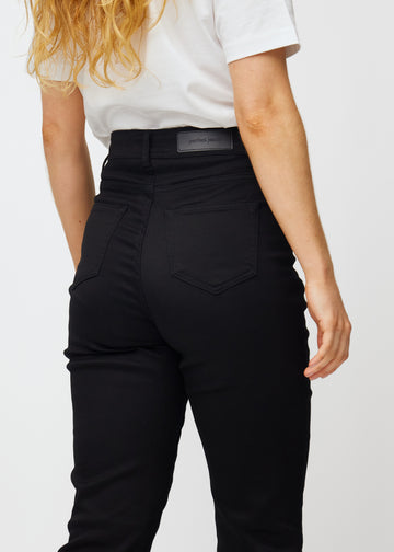 Black high-waisted regular jeans seen from the back in close-up to show details.