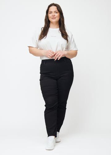 Full image of a plus-size model in black high-waisted slim jeans.